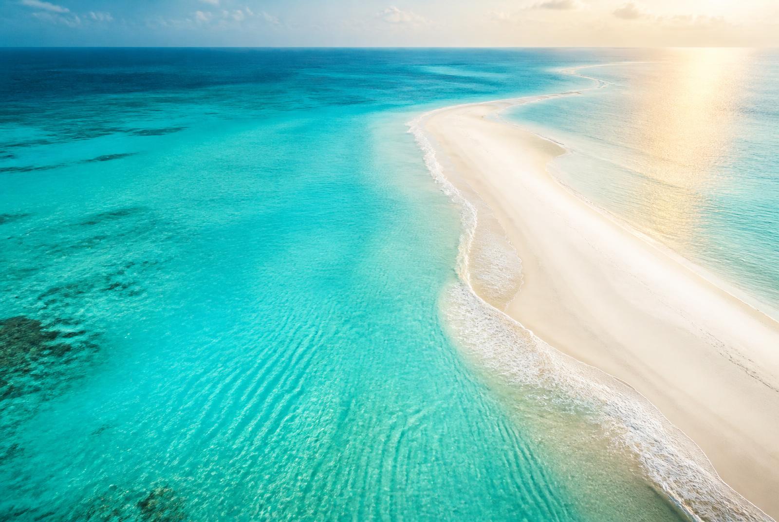 Crystal clear turquoise water along a white sandbar in the Caribbean